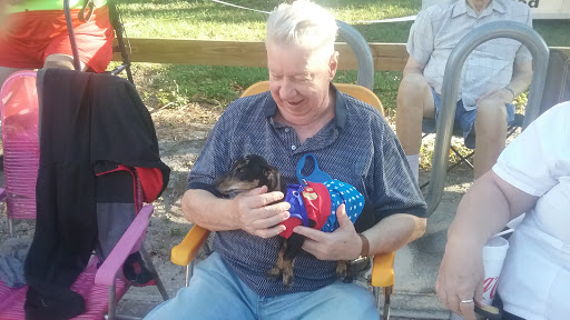 A man enjoying a sunny day outdoors with his pet dog.