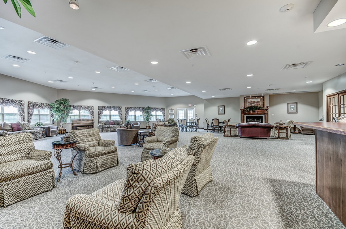 A spacious living room with comfortable seating, a fireplace, and large windows.