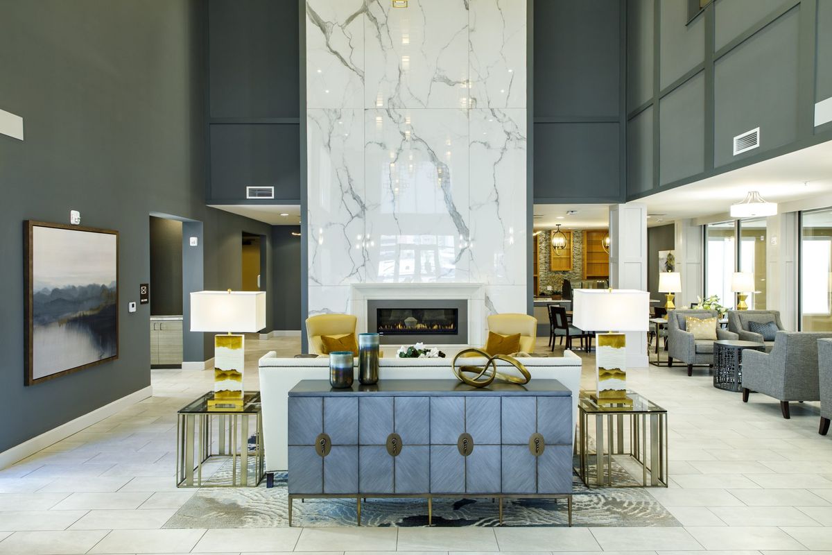 A luxurious and modern lobby featuring elegant furniture and a central fireplace.