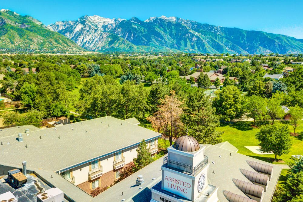 A scenic view of buildings surrounded by lush greenery with mountains in the background.