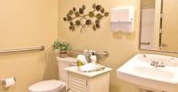 A neatly organized bathroom with decorative wall art and essential amenities.