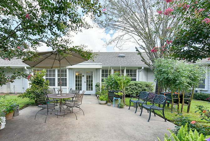 An inviting outdoor patio area with seating and lush greenery.