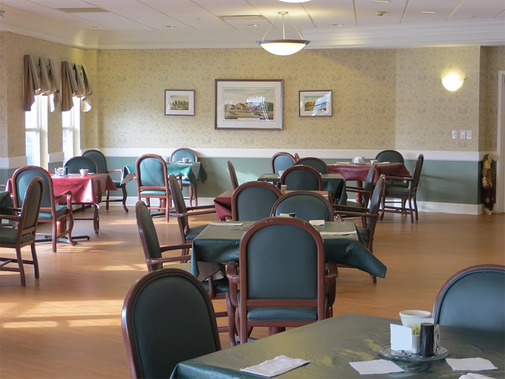 An empty dining room with neatly arranged tables and chairs.