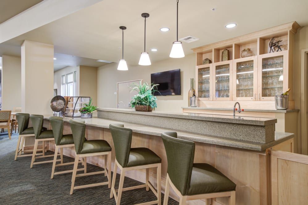 A modern kitchen area with bar seating and pendant lighting.