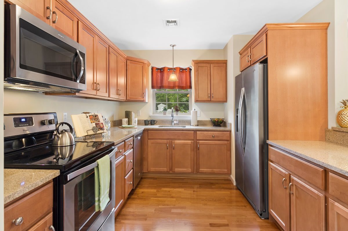 A modern kitchen with wooden cabinets and stainless steel appliances.
