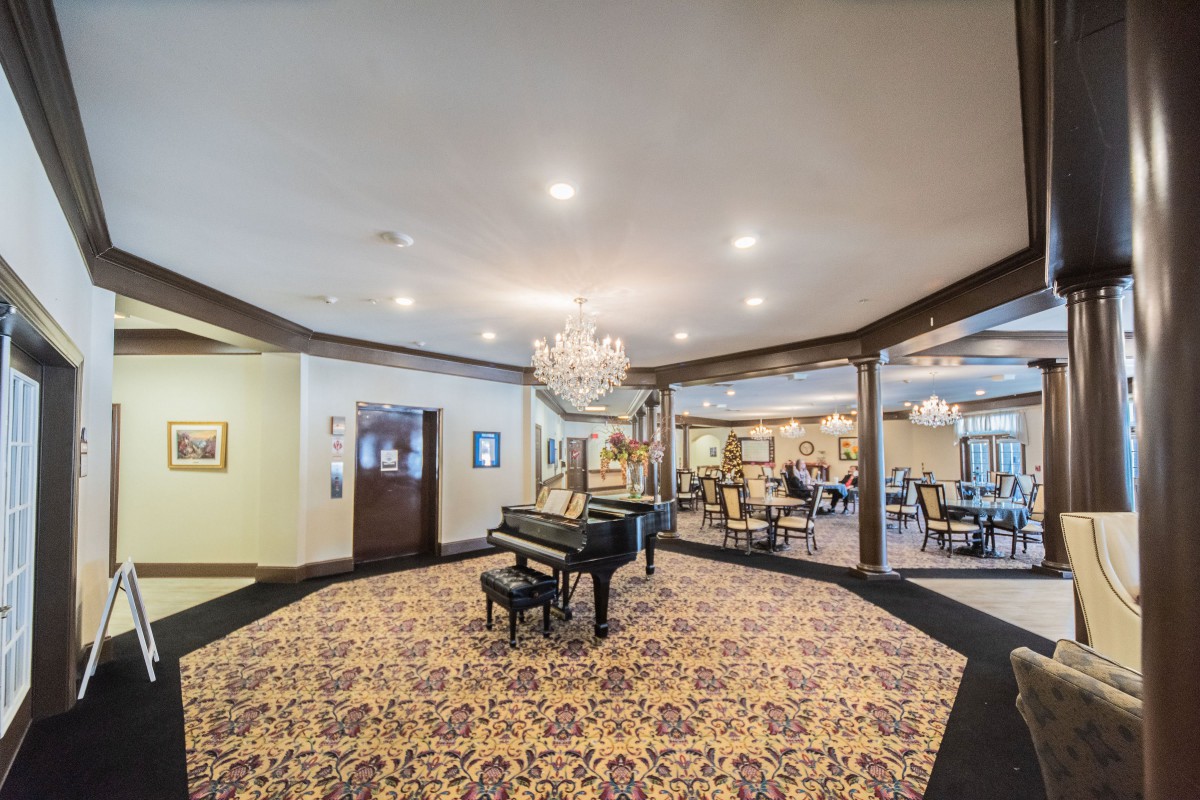 A spacious lobby featuring a grand piano and elegant chandelier.