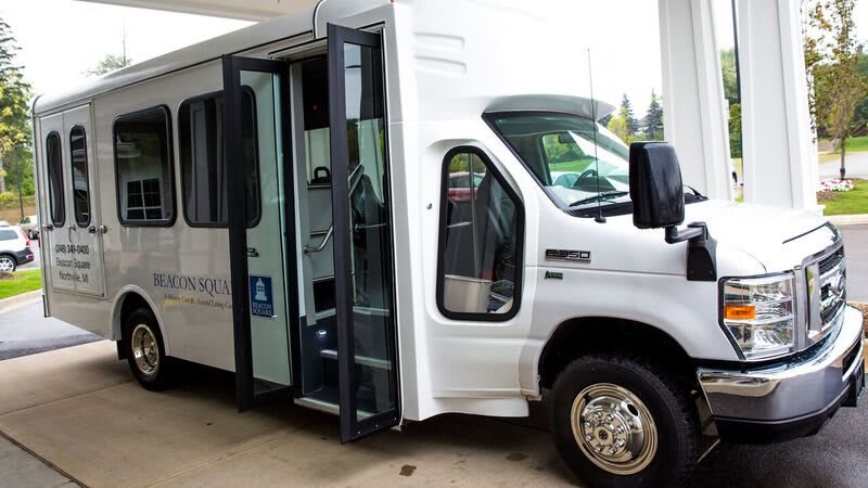 A white shuttle bus with its door open, ready for passengers.