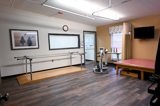 A well-equipped physical therapy room featuring walking bars and exercise equipment, designed for rehabilitation and patient care.