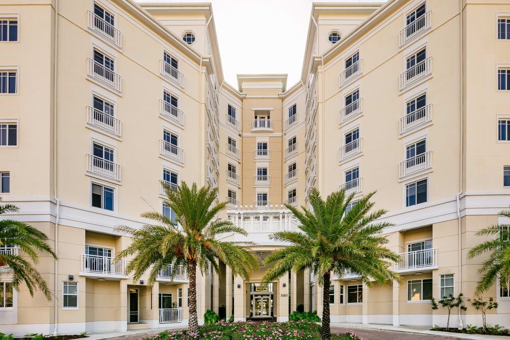 A grand hotel entrance flanked by palm trees with symmetrical architecture.