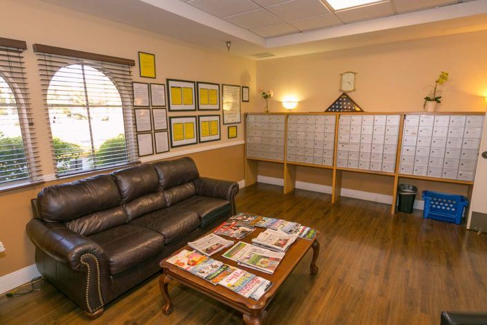 A cozy waiting room with a leather sofa and magazines on a wooden coffee table.