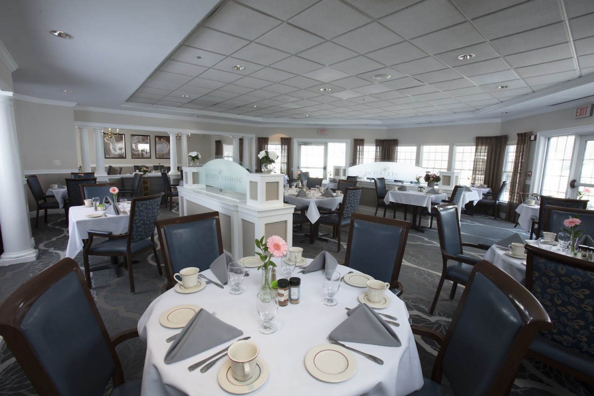 An elegantly set dining room with neatly arranged tables and chairs.