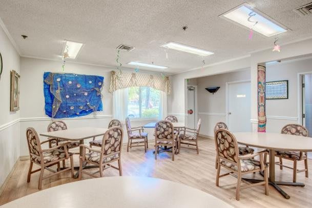 A bright and airy community dining area with tables and chairs set up for gatherings.