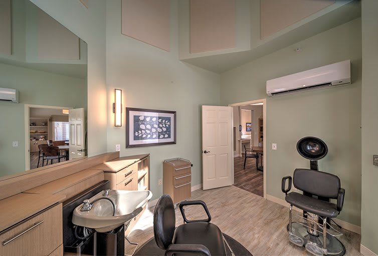 A modern hair salon interior with a styling chair and mirror.