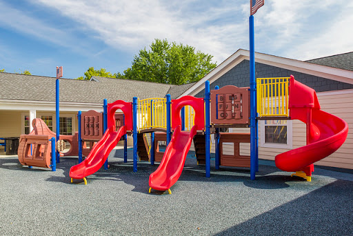 A vibrant playground featuring red slides and colorful play structures, perfect for outdoor fun.