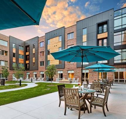 Modern apartment complex with outdoor seating and landscaped courtyard.