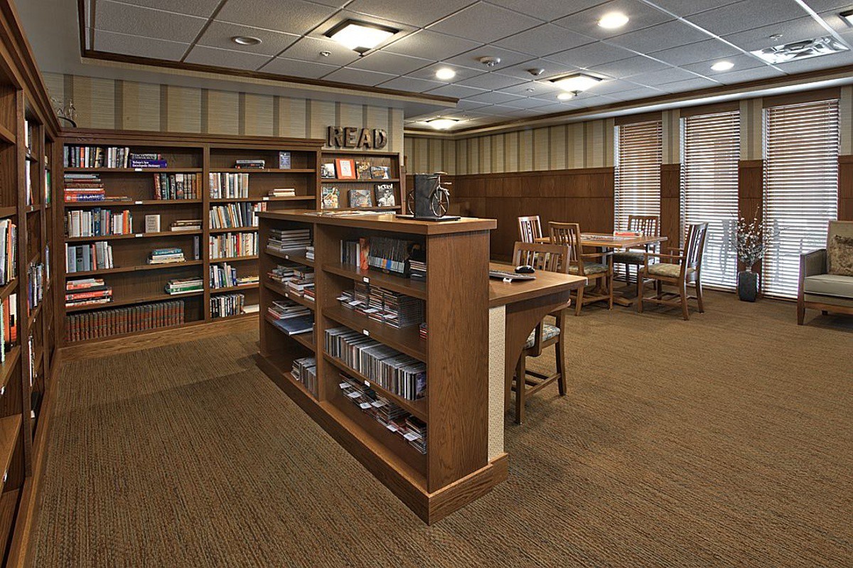 A cozy library reading area with bookshelves and seating arrangements.