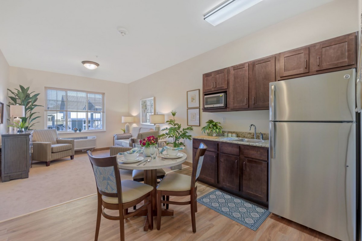 A modern apartment featuring a cozy kitchen and dining area with contemporary furniture and bright lighting.