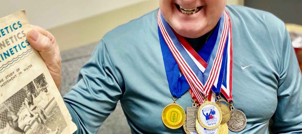 A person wearing multiple medals, showcasing a significant achievement in sports or competition.