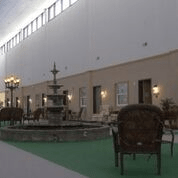 An indoor space featuring a fountain surrounded by seating and warm lighting.