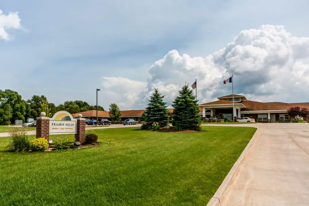 A hospital with a well-maintained lawn and a cloudy sky in the background.