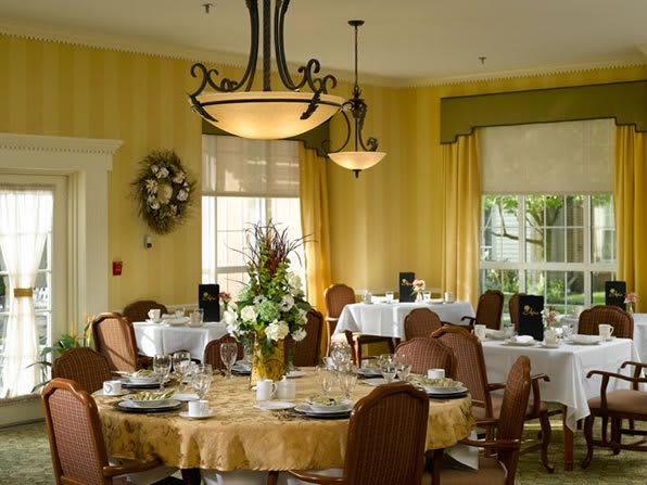 An elegant dining room with neatly set tables and stylish chandeliers.