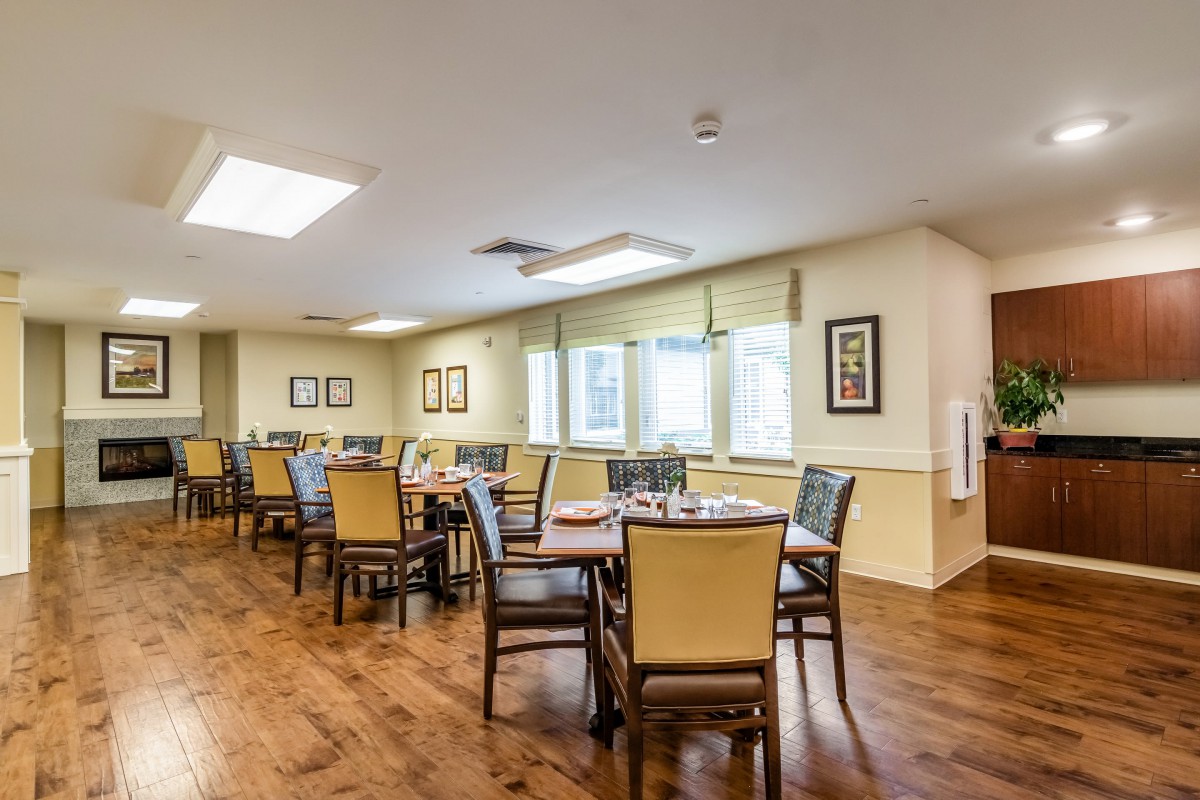 A well-lit dining area with neatly arranged tables and chairs.