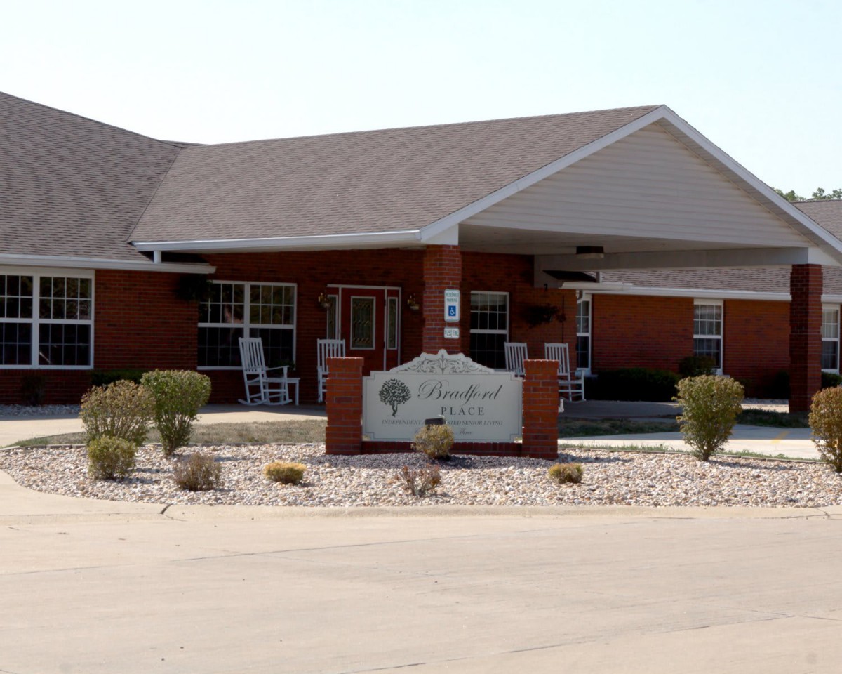 A single-story building with a sheltered entrance and surrounding landscaping.