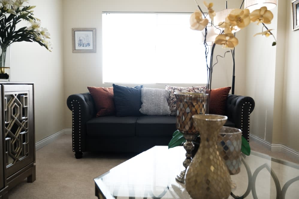 A cozy living room with a comfortable sofa, decorative cushions, and elegant vases on the table.
