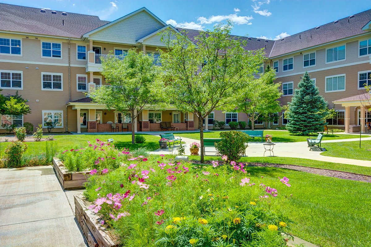 A sunny day at an apartment complex with a beautifully landscaped garden and courtyard.