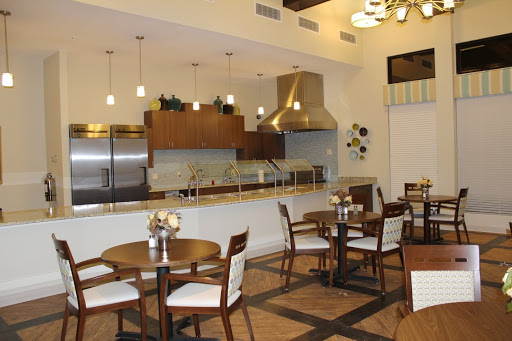 A modern dining area featuring an open kitchen and elegantly arranged tables.