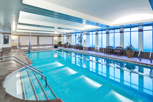 A serene indoor swimming pool area featuring modern design and ample natural light.