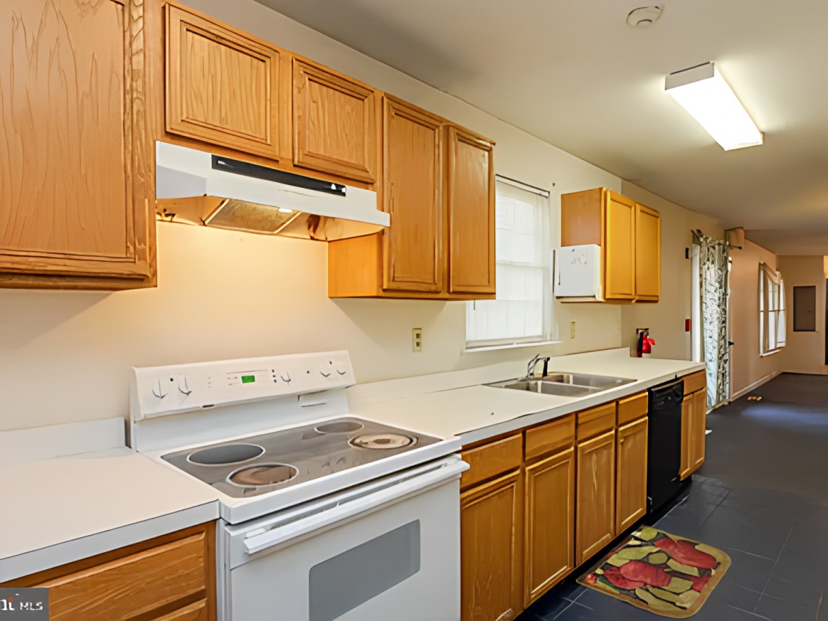A modern kitchen with wooden cabinets, an oven, and a sink.