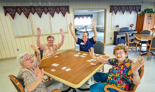 A group of cheerful older adults enjoying a card game together, celebrating their time spent in good company.
