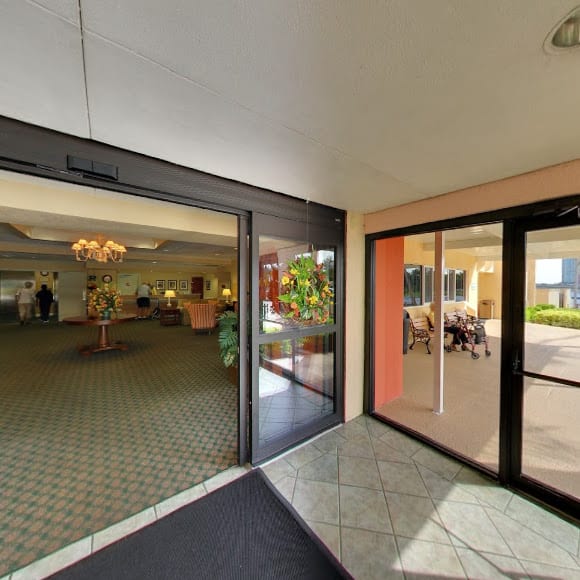 View of a hotel lobby with open glass doors leading to the interior.