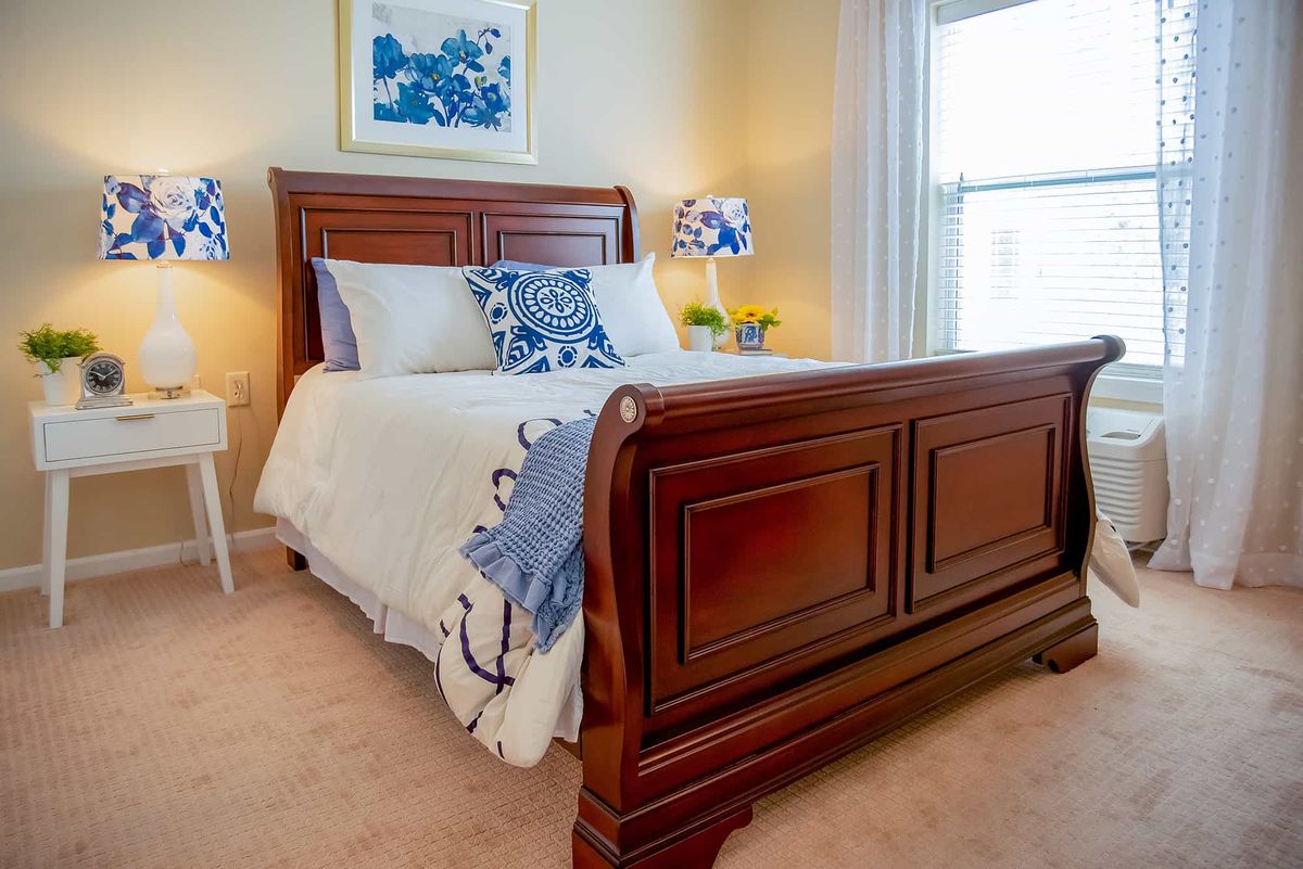 A cozy bedroom with a wooden bed frame and nautical-themed decor.