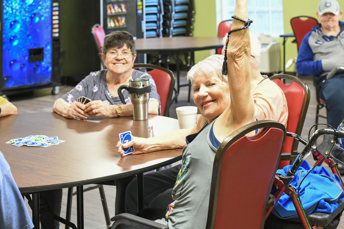 A group of seniors enjoying a card game together indoors, sharing laughter and camaraderie.