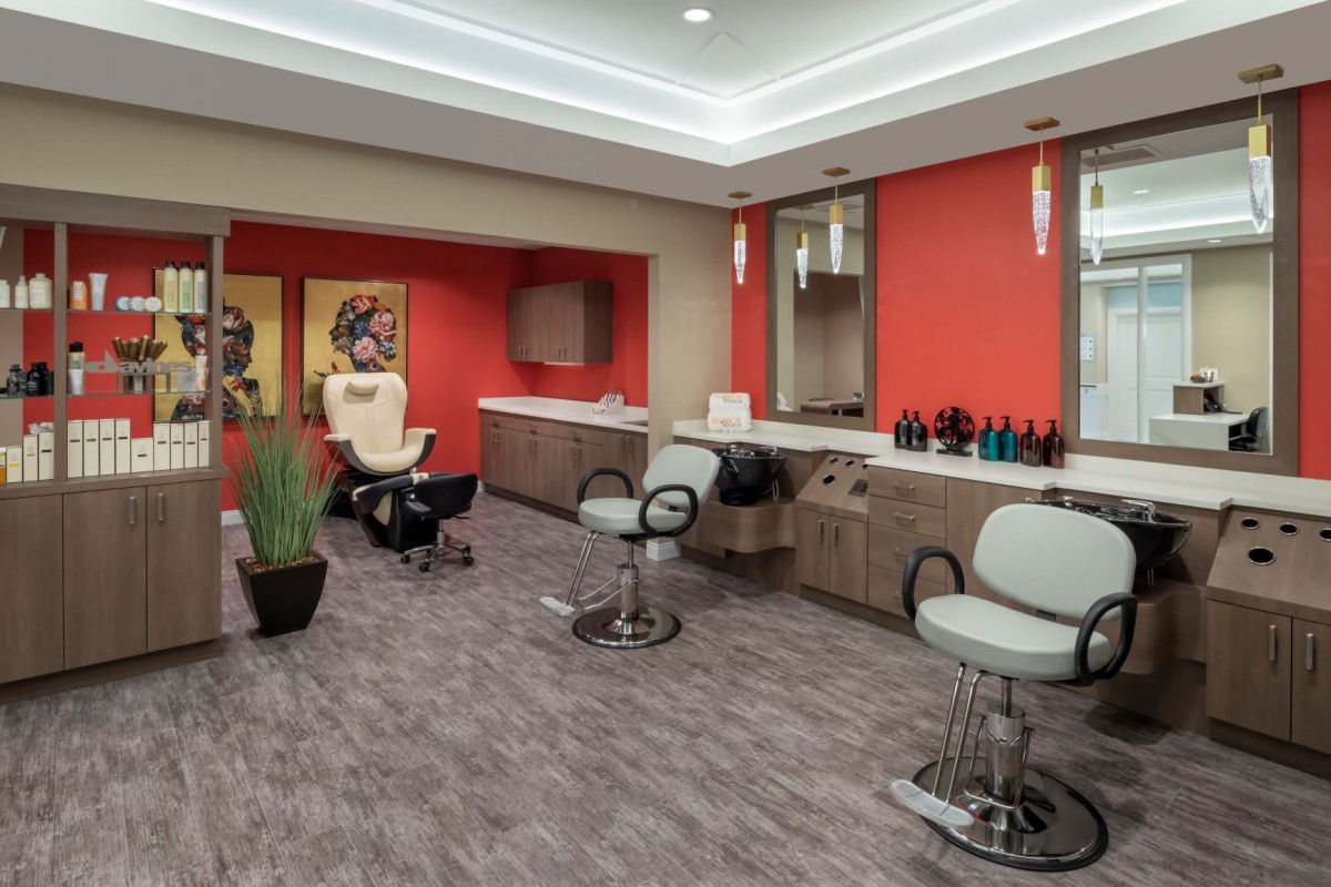 Modern hair salon interior with vibrant red walls and stylish furnishings.