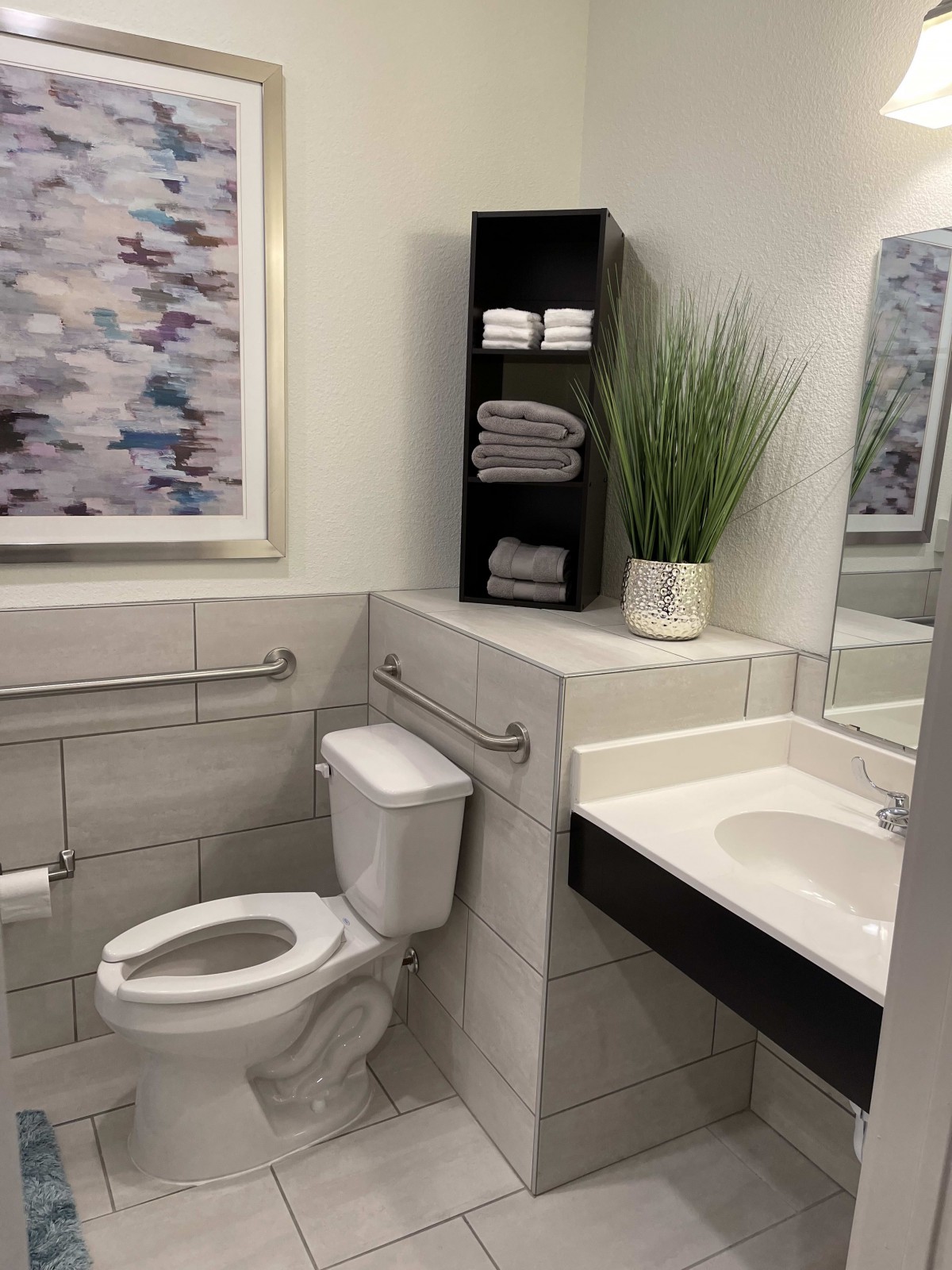 A modern bathroom with a toilet, sink, and stylish decor.