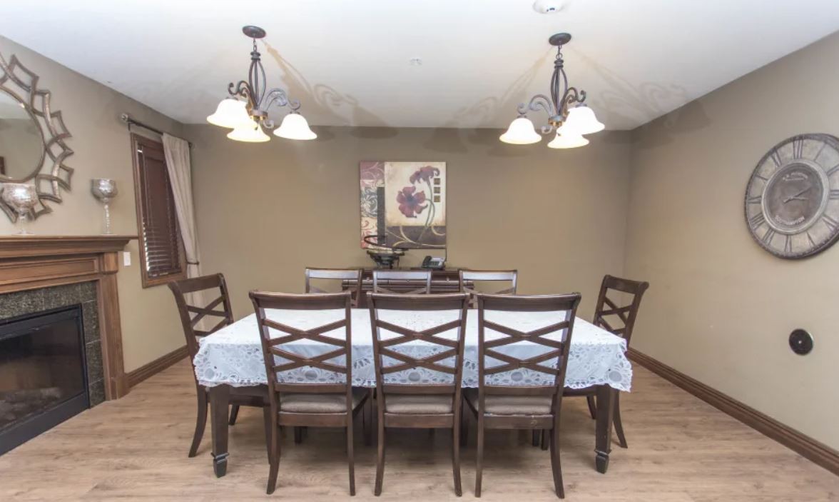 A dining room with a wooden table set and elegant lighting.
