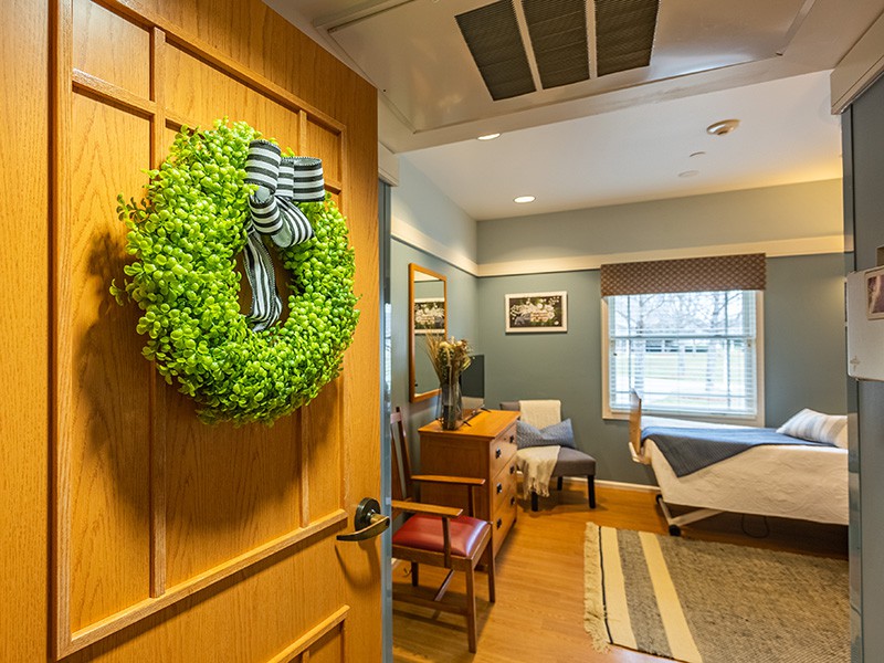 A cozy waiting room with a wreath on the door and comfortable seating.