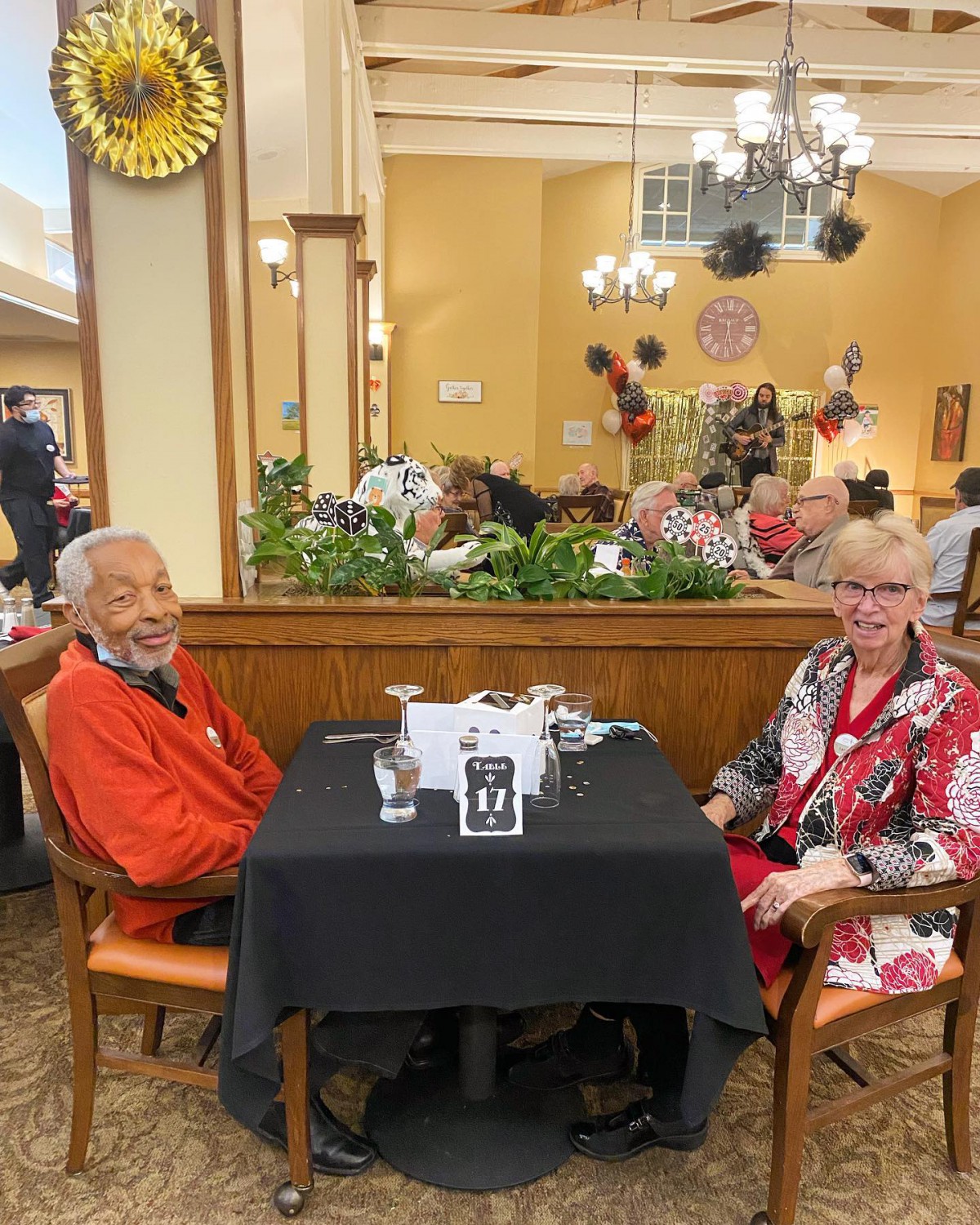 Two individuals enjoying a meal together at a restaurant, seated at a table with elegant decor.