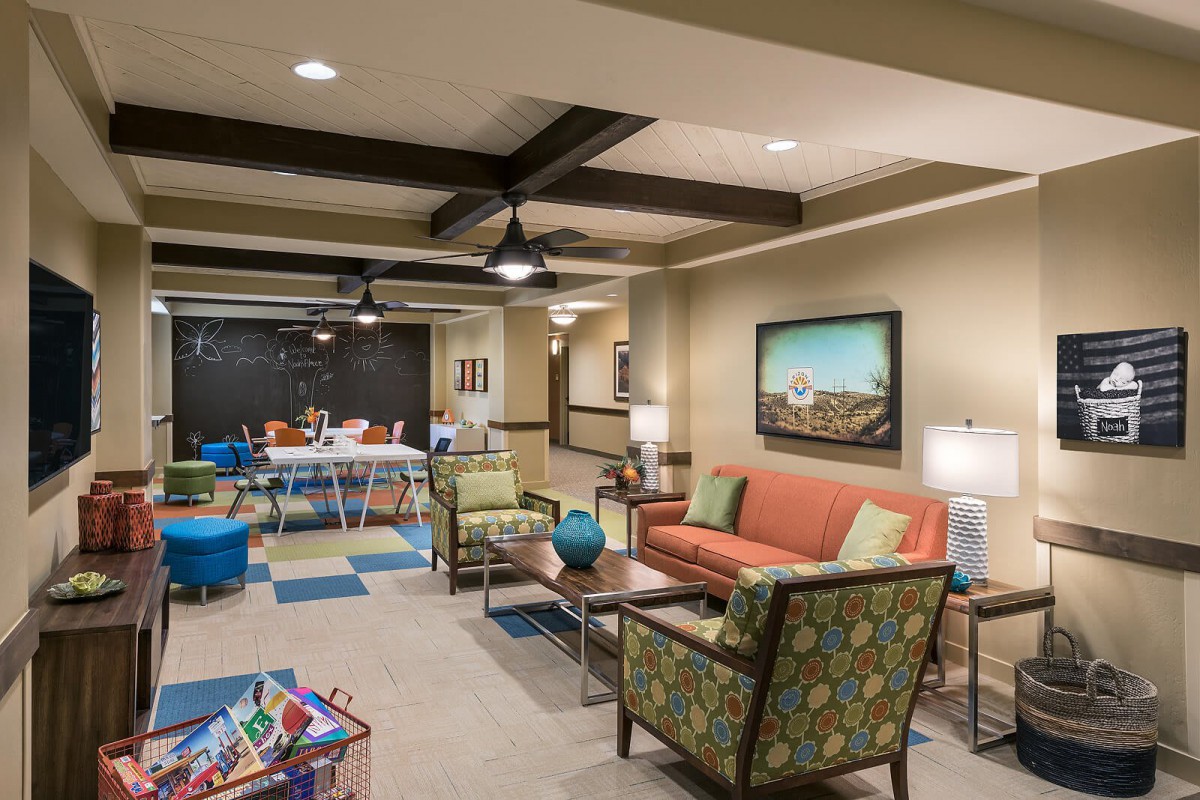 A modern indoor lounge area with comfortable seating and a play space for children.