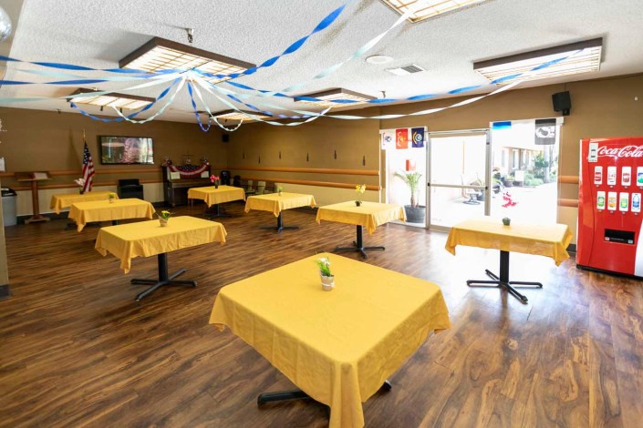 A well-decorated restaurant interior with tables covered in yellow tablecloths.