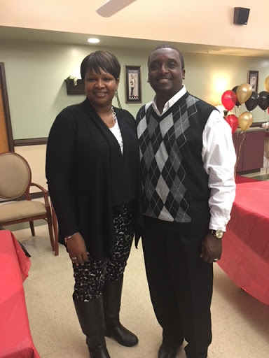 A joyful moment captured at a celebration, showcasing two individuals dressed in formal attire.