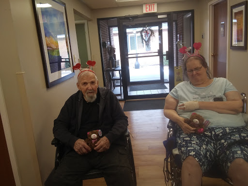 Two residents in a care home enjoying a festive moment with reindeer antlers.