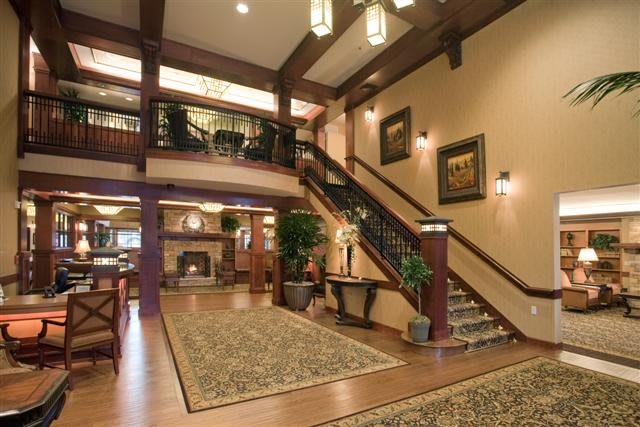 Elegant hotel lobby with wooden beams, staircase, and cozy decor.