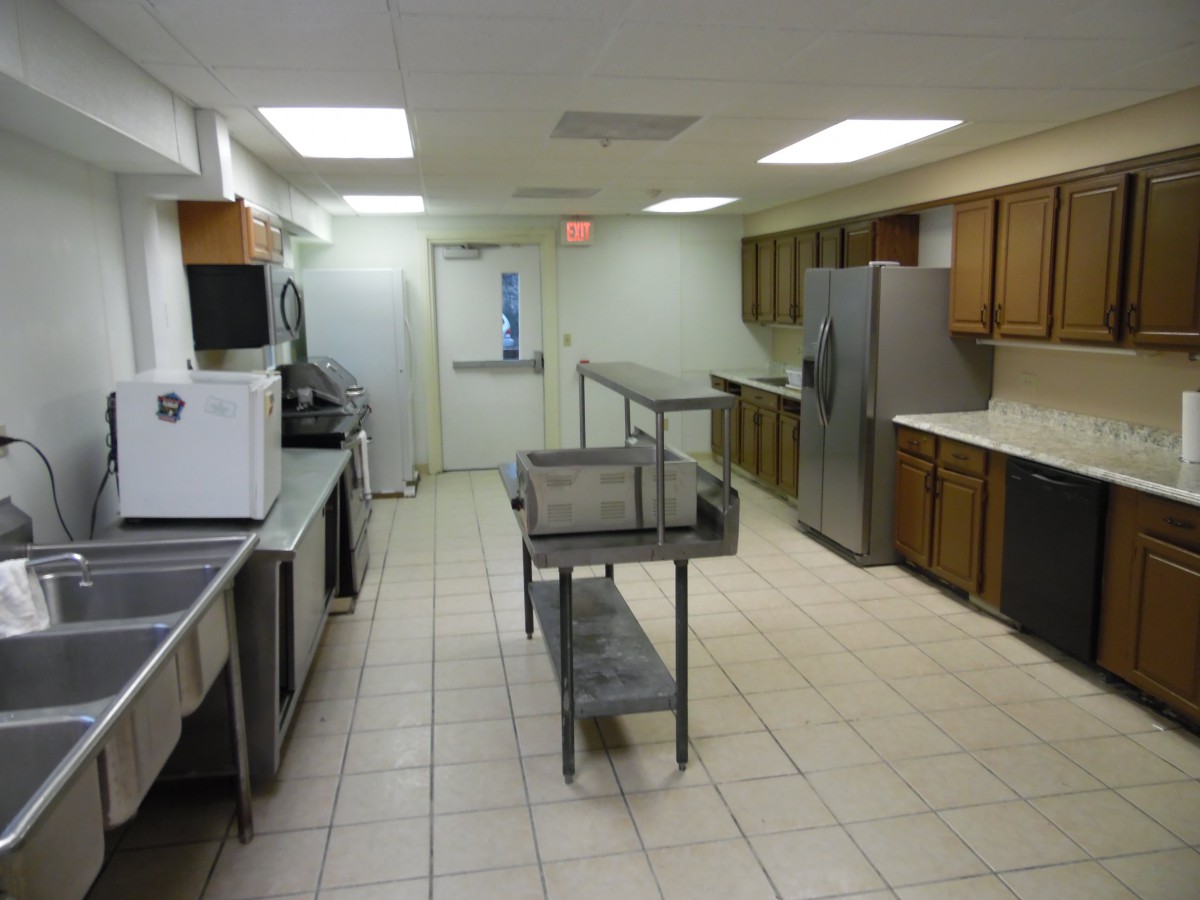 A clean commercial kitchen with stainless steel appliances and a central island.