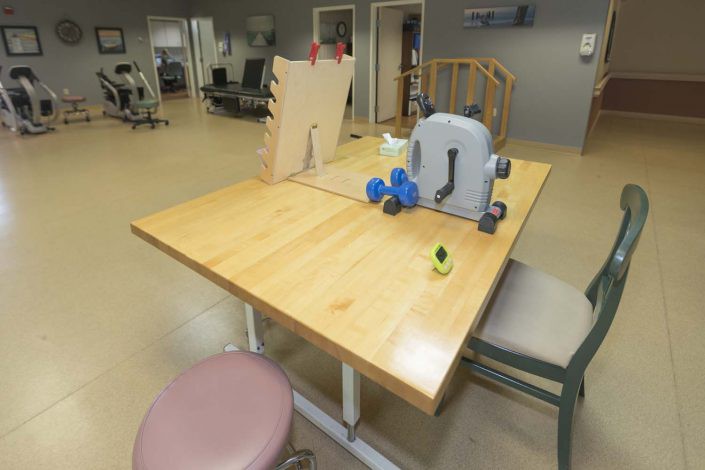 A physical therapy room with exercise equipment on a wooden table.