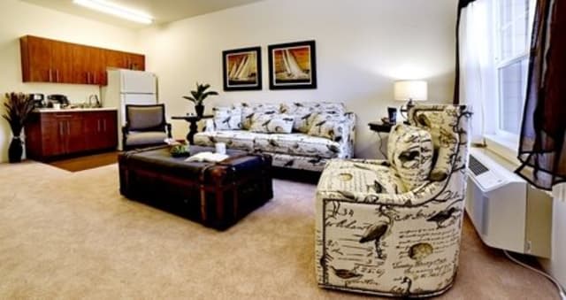 A cozy living room with a patterned sofa and armchair, complemented by a coffee table.