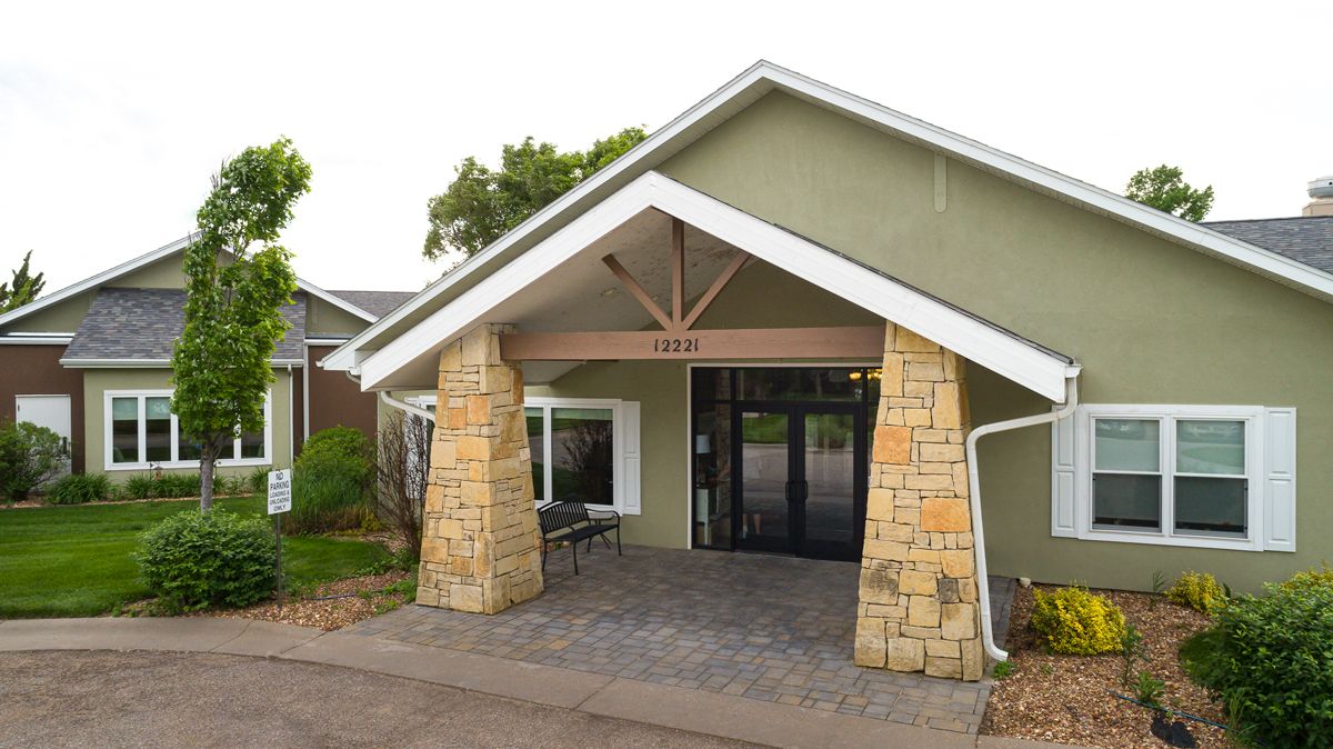 A building entrance with stone pillars and a gabled roof.